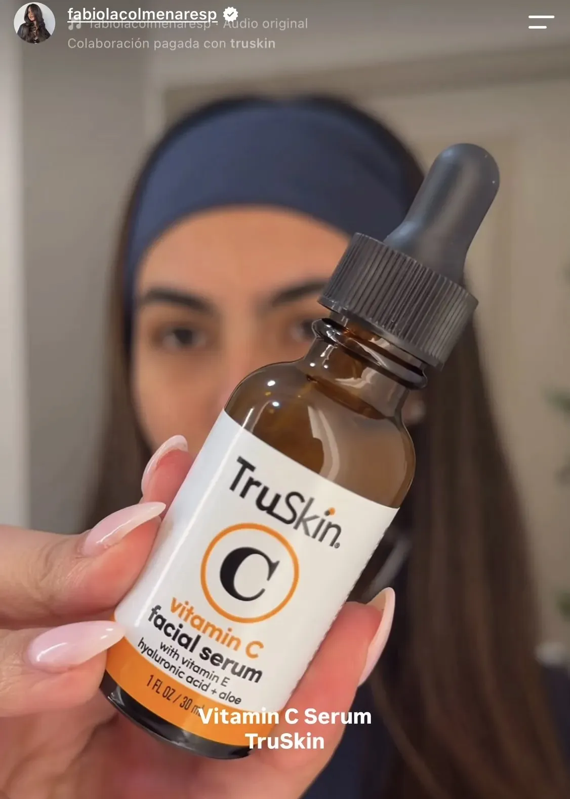 Fabiola mostrando el sérum de vitamina C de TruSkin