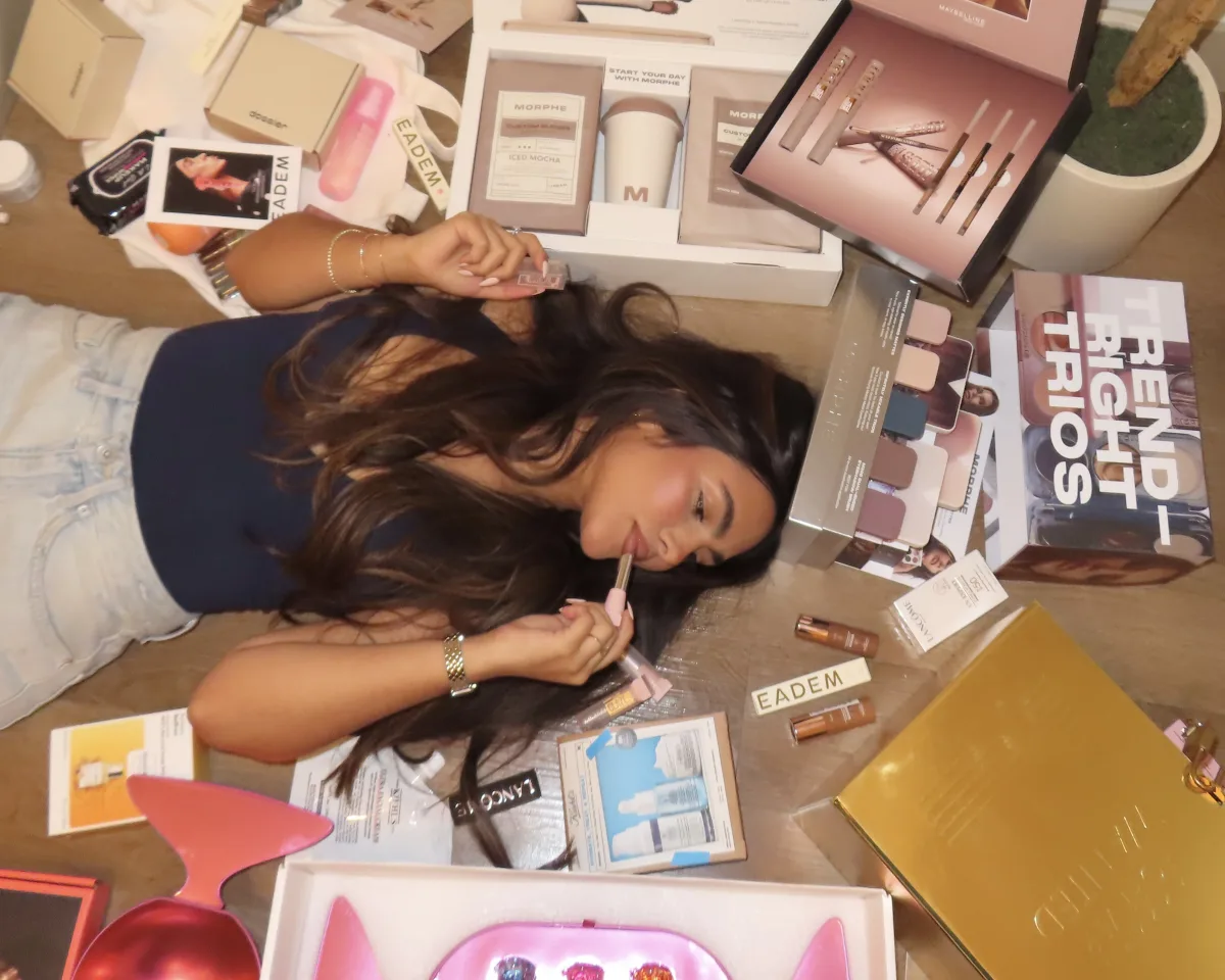 Creadora rodeada de productos de belleza mientras graba contenido UGC