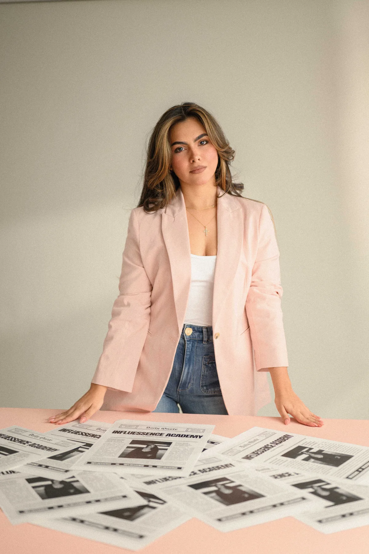 Fabiola, fundadora de Influessence Academy, de pie junto a una mesa con recortes de prensa de la academia
